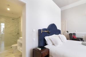 a white bedroom with a bed and a shower at 1869 Príncipe Real House in Lisbon +37 photos
