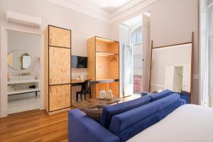 a bedroom with a bed and a blue couch at 1869 Príncipe Real House in Lisbon