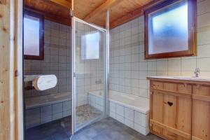 Un baño con ducha, bañera y lavabo. en LES SERMES M504, en Morzine 17 fotos más