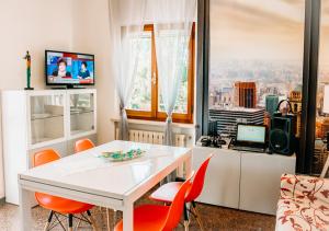 a dining room with a white table and orange chairs at L'Isola che non c'è in Senigallia