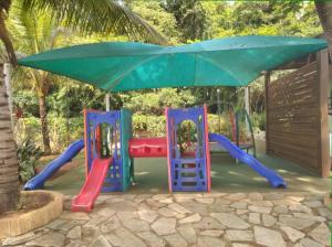 einen Spielplatz mit Rutsche und Sonnenschirm in der Unterkunft Aldeia Do Lago ,304.caldas novas in Caldas Novas