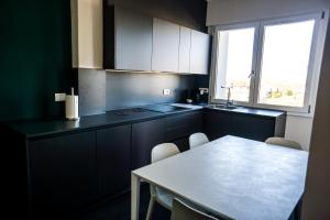 cocina con armarios negros, mesa y ventana en Venice Terminal Apartments & Suites, en Mestre 23 fotos más