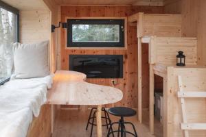 a tiny house with a table and a bed and a window at ENJOY COZY Tree House Hills Forest Gardens Beautiful Views Sauna Hotbath in Jablonné v Podještědí