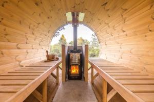 una habitación con estufa de leña en una cabaña de madera en ENJOY COZY Tree House Hills Forest Gardens Beautiful Views Sauna Hotbath en Jablonné v Podještědí