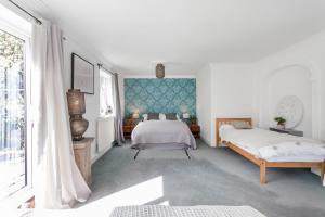 a white bedroom with two beds and a window at Quorn Farmhouse in Quorndon