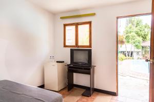 um quarto com uma televisão e um pequeno frigorífico em Ayenda 1257 Premium Real em Medellín