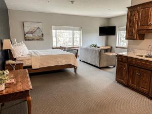 een slaapkamer met een bed en een bank in een kamer bij Inn at Amish Door in Wilmot