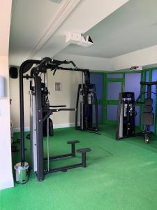 une salle de sport avec plusieurs tapis roulants et tapis vert dans l'établissement Best Western Ipswich Hotel, à Ipswich