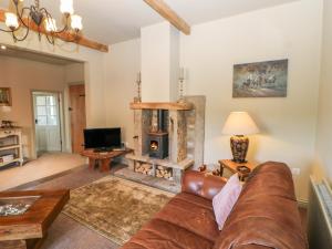a living room with a couch and a fireplace at Low Shipley Cottage in Cotherstone