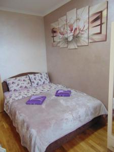 a bedroom with a bed with purple towels on it at Apartman Magic Zlatibor-Čajetina in Čajetina