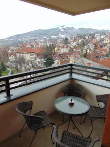 a balcony with a table and chairs and a view at Apartman Magic Zlatibor-Čajetina in Čajetina