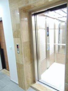 una porta a vetri che conduce a un ascensore in un edificio di Apartman Magic Zlatibor-Čajetina a Čajetina