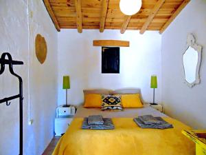 a bedroom with a large bed with yellow sheets at Suão Retiro Alentejano in Amieira