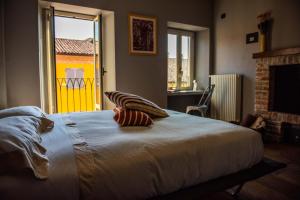 a bedroom with a large bed with two pillows on it at Boutique Hotel Al Palazzo Rosso in Neive