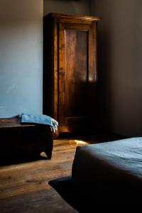 Habitación con cama y puerta de madera en Boutique Hotel Al Palazzo Rosso, en Neive