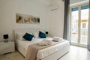 a bedroom with a white bed with towels on it at Chez moi in Siracusa