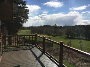 a wooden deck with a view of a green field at Millie,s View 18 hole free Golf in Swarland