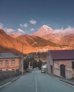 eine Straße in einer Stadt mit Bergen im Hintergrund in der Unterkunft Ineza's Guest House in Kazbegi