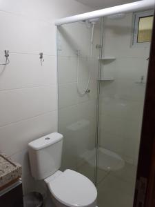 uma casa de banho com um WC e uma cabina de duche em vidro. em Flat 102 com vista parcial do Mar! em Cabedelo