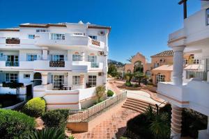a large white building with stairs in front of it at Spectacular Apartment in Matchroom Country Club in Fuengirola