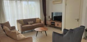 ein Wohnzimmer mit einem Sofa und einem TV in der Unterkunft Antalya belek Mermaid villas 3 bedrooms close the beach park 1 in Belek