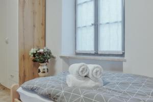 Dos toallas sentadas en una cama con ventana en Apartments Pr' Štormanu, en Kanal