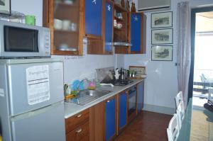 a kitchen with a sink and a refrigerator at Appartamento Teocle beach in Giardini Naxos +11 photos