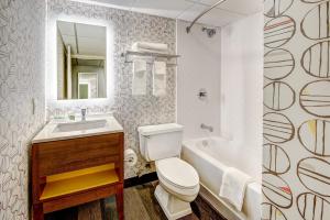 a bathroom with a toilet and a sink and a tub at Holiday Inn East Windsor - Cranbury Area in Hightstown