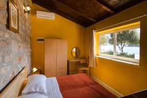 a small bedroom with a bed and a window at Guest House Simunovic in Suđurađ