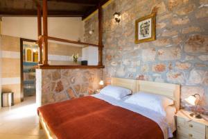 a bedroom with a stone wall with a bed at Guest House Simunovic in Suđurađ