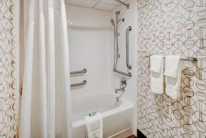 a bathroom with a white shower curtain and a tub at Holiday Inn East Windsor, an IHG Hotel in Hightstown