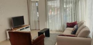 a living room with a couch and a tv at Antalya belek green park golf apart ground floor 2 bedrooms close the beach park in Belek