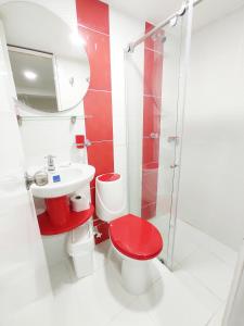 uma casa de banho com um WC vermelho e um lavatório. em Hotel Casablanca Cañaveral em Floridablanca