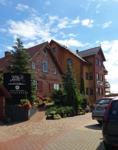 a building with a sign in a parking lot at Monika in Krynica Morska