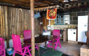 een keuken met een houten tafel en roze stoelen bij Chalet de Lujo en La Manga in Cartagena