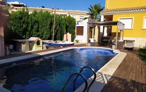 a swimming pool in front of a house at Chalet de Lujo en La Manga in Cartagena