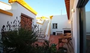 a house with a stairway leading to a patio at Casa Ocre in Vila Nova de Milfontes