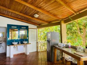 a kitchen with a stainless steel refrigerator and two sinks at Coibahouse Ocean Front Eco-Stay in Santa Catalina