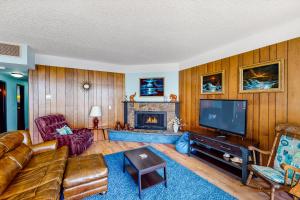 a living room with a couch and a fireplace at Sand and Sea #304 in Seaside