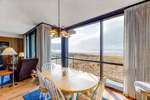 a dining room with a table and chairs and a large window at Sand and Sea #304 in Seaside