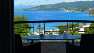a table on a balcony with a view of the water at George & Sia's House in Neos Marmaras