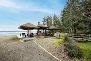 a picnic area with tables and umbrellas next to the water at Hartstene Pointe Haven in Shelton