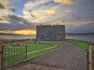 a castle with a flag on top of it at Mingary Castle - Restaurant with Rooms in Kilchoan