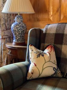 a pillow sitting on a couch next to a lamp at Mingary Castle - Restaurant with Rooms in Kilchoan