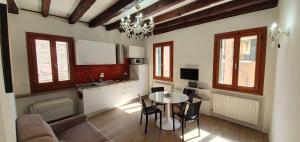 a living room with a table and a kitchen at Ca' Venice Canal View in Venice
