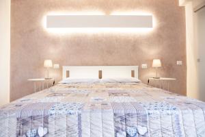 een slaapkamer met een groot bed en 2 tafels bij La corte di Emma e Ale in Volta Mantovana