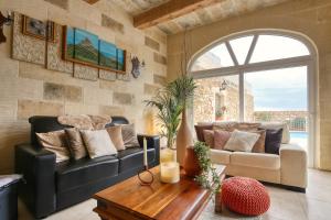 a living room with a couch and a table at Sweet Life Gozo in Santa Luċija