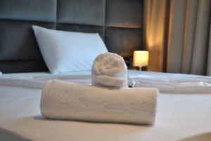 een handdoek bovenop een bed bij Twin Towers Hotel City & Beach Resort in Shëngjin