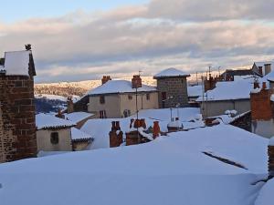 a town covered in snow with roofs at Duplex centre ville in Saint-Flour