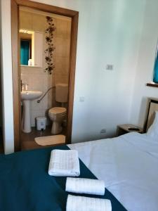 ein Schlafzimmer mit einem Bett und ein Badezimmer mit einem Waschbecken in der Unterkunft Pensiunea Corina Tulcea in Tulcea